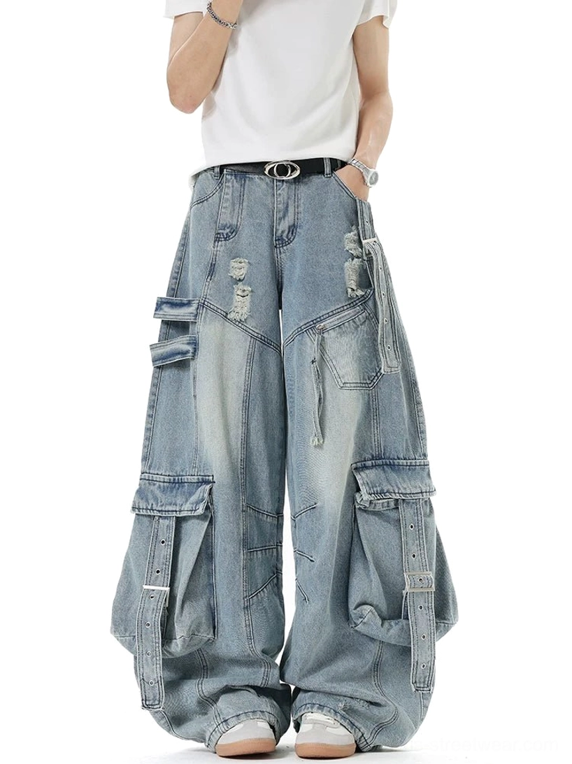 Front three-quarter view of vintage light blue cargo denim pants with wide loose legs, ripped details, and layered utility straps