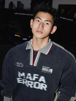 Close-up view of a vintage rugby polo sweatshirt showing washed fabric texture, striped collar trim, layered chest patches, and graphic Korean inspired streetwear details
