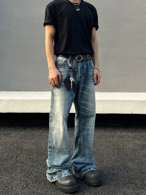 Male model wearing light blue vintage stonewash flared jeans with faded whiskering in an outdoor streetwear outfit