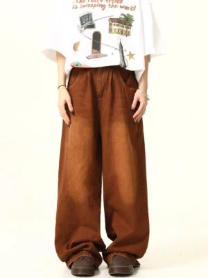 Front view of brown vintage washed wide leg denim pants styled with a graphic white T-shirt and loafers