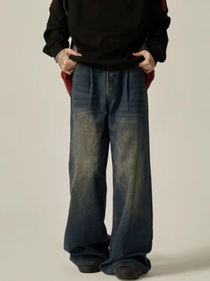 Front low-angle view of vintage dark blue high-waisted wide-leg jeans with pleated waist, faded thighs, and relaxed streetwear fit