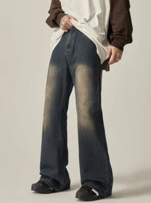 Front left full-body view of blue vintage wash wide leg jeans styled with a color-block long-sleeve streetwear shirt and casual skate shoes