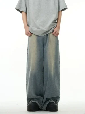 Front view of vintage washed blue wide-leg streetwear jeans styled with an oversized grey T-shirt and platform sneakers