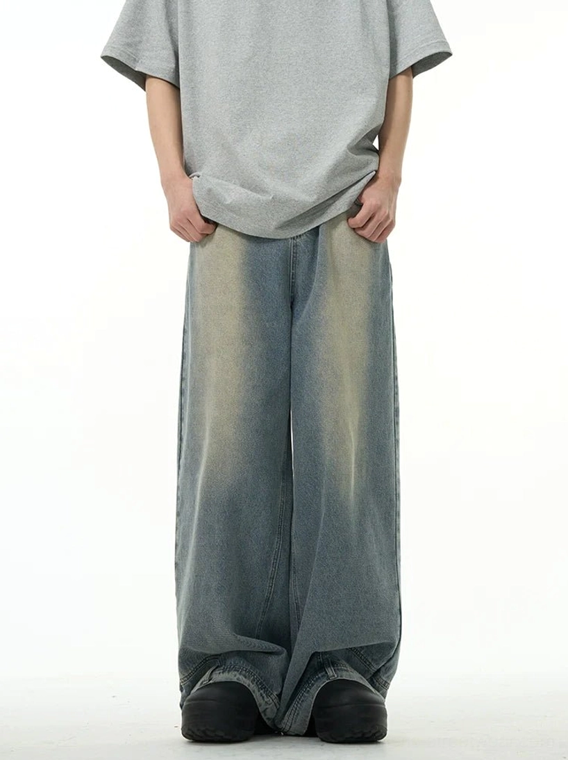 Front view of vintage washed blue wide-leg streetwear jeans styled with an oversized grey T-shirt and platform sneakers