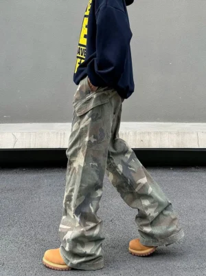 Side view of vintage washed camo cargo pants showing the oversized wide leg fit, faded cotton texture, and flap utility pocket