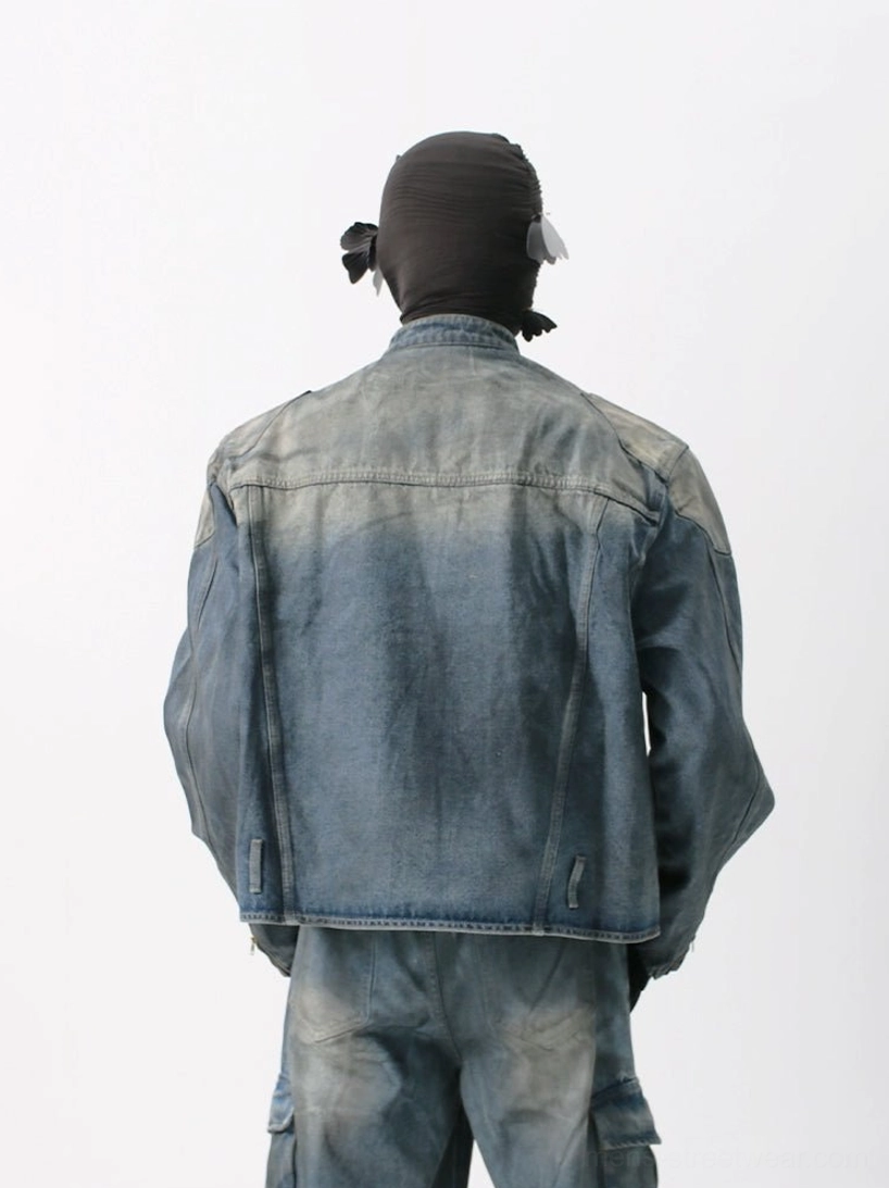 Rear view of a vintage washed denim moto jacket showing back yoke seam detailing, adjustable hem tabs, faded blue denim finish, and coordinated urban streetwear styling