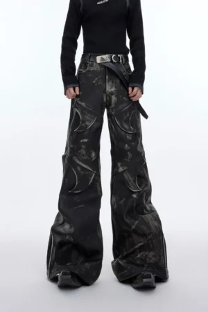 Front low-angle view of vintage washed black faux leather flare cargo pants with oversized side pockets and distressed finish