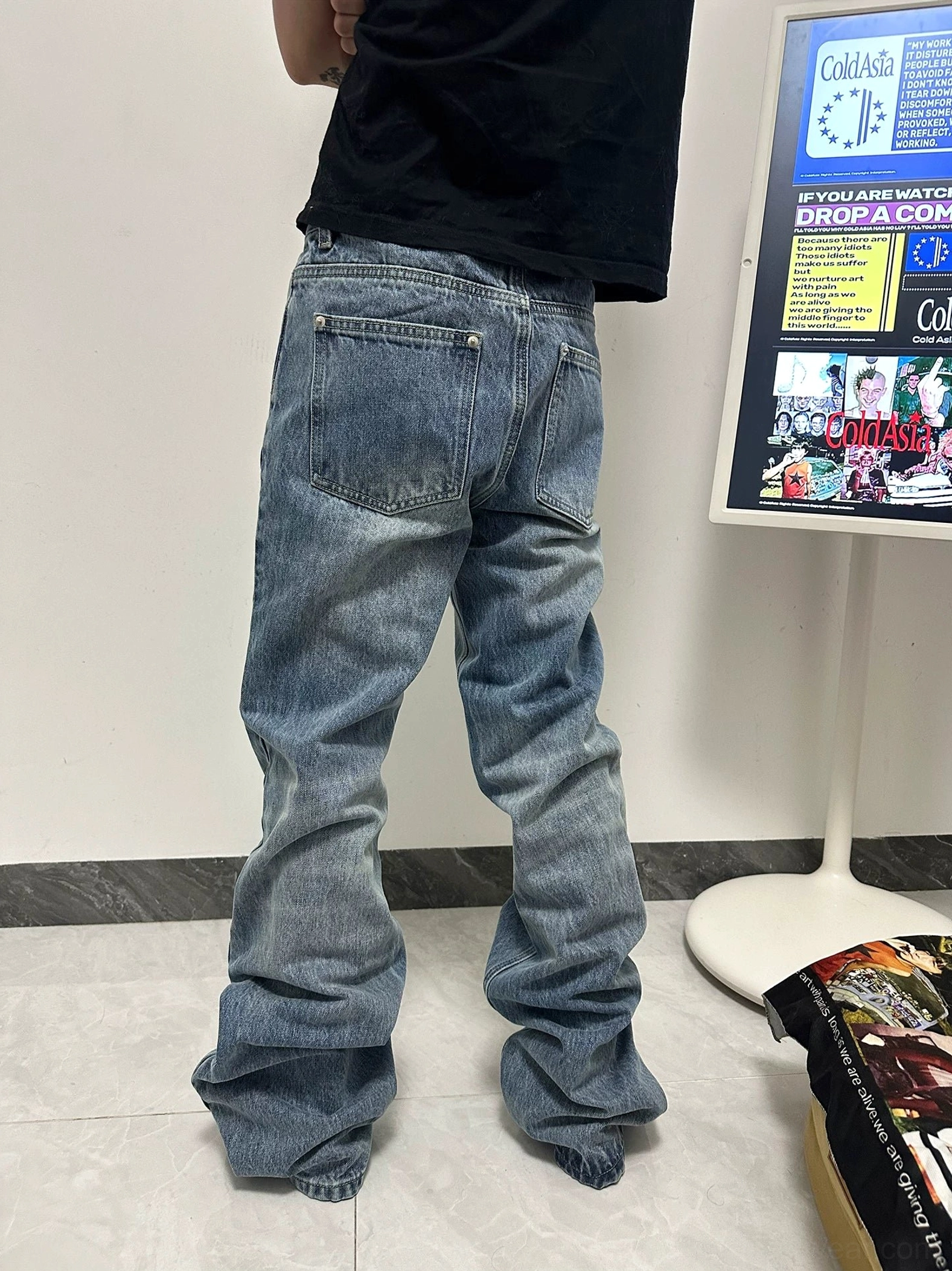 Back view of vintage washed flare jeans showing classic denim pockets elongated flared legs and ankle stacking