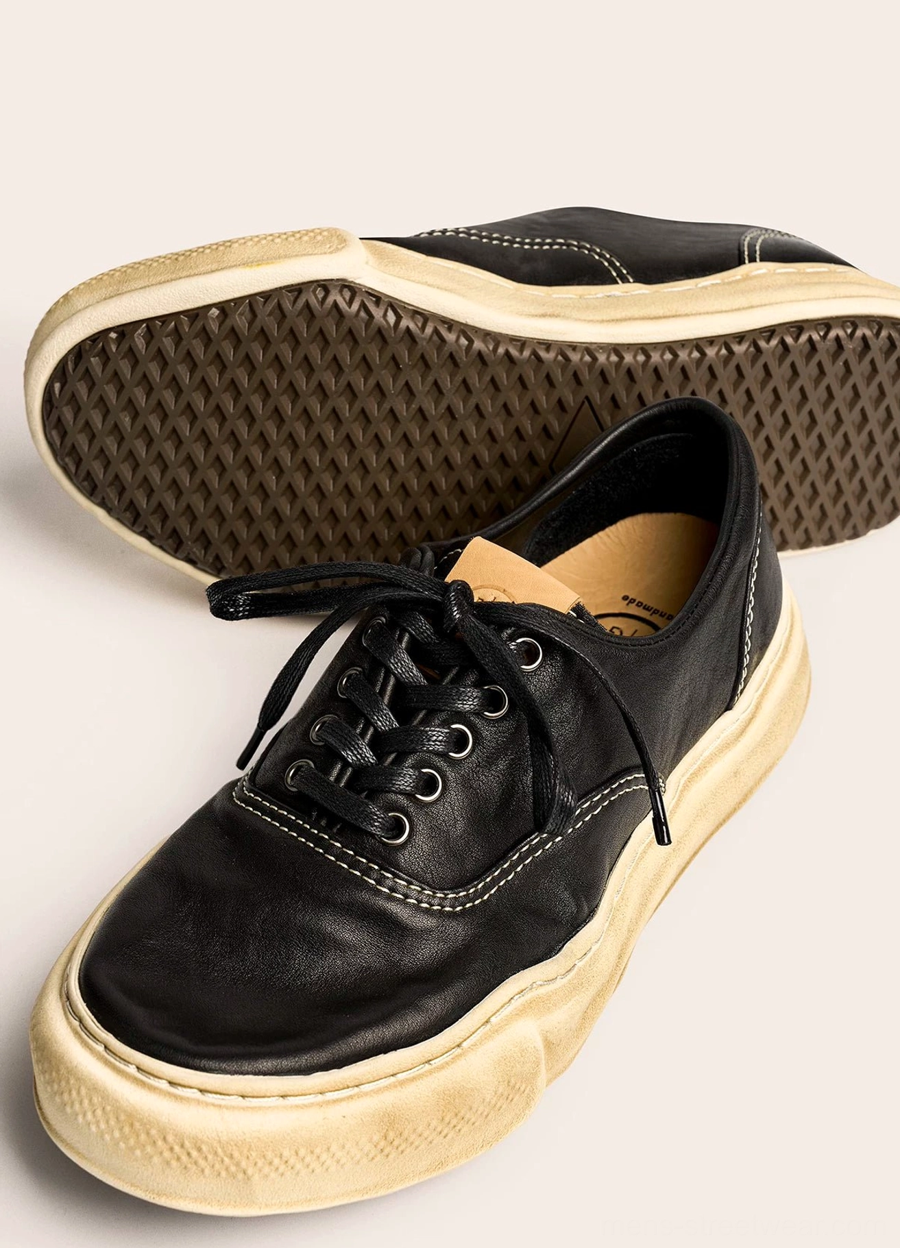 Vintage-inspired washed leather casual sneakers with distressed texture, substantial retro sole, and versatile East Asian streetwear silhouette