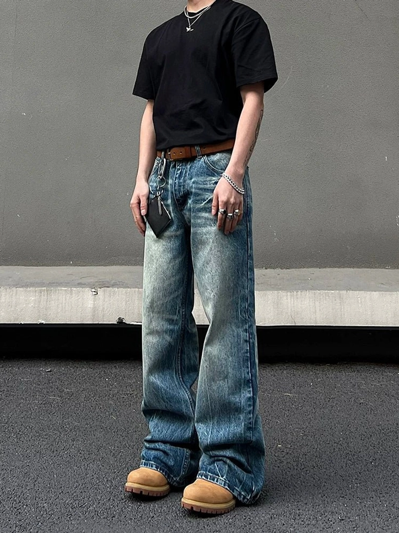 Front full body view of vintage washed blue wide leg jeans styled with a black t-shirt and tan work boots