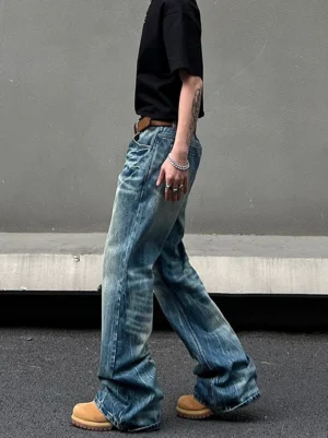Side profile of faded blue vintage wide leg denim jeans with long stacked hem and brown leather belt