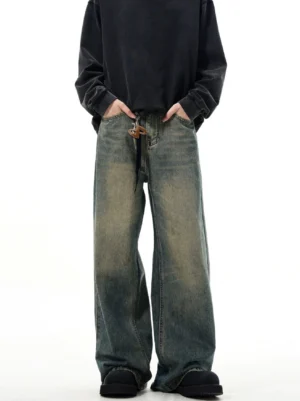 Front full-body view of vintage washed wide-leg jeans with drawstring waist, faded blue denim, and black streetwear styling