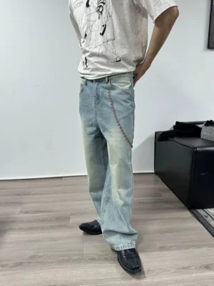 Male model wearing light blue vintage washed wide-leg jeans with a relaxed stacked streetwear fit and side chain detail