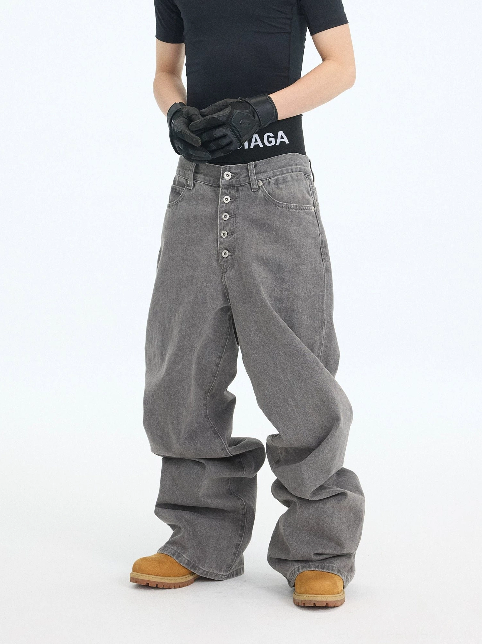 Front detail of washed ash denim jeans highlighting the extended five-button fly and oversized baggy workwear silhouette