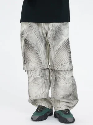 Front view of washed ash grey moto convertible cargo pants with oversized loose fit, 3D stitched panels, and dark green outdoor sneakers