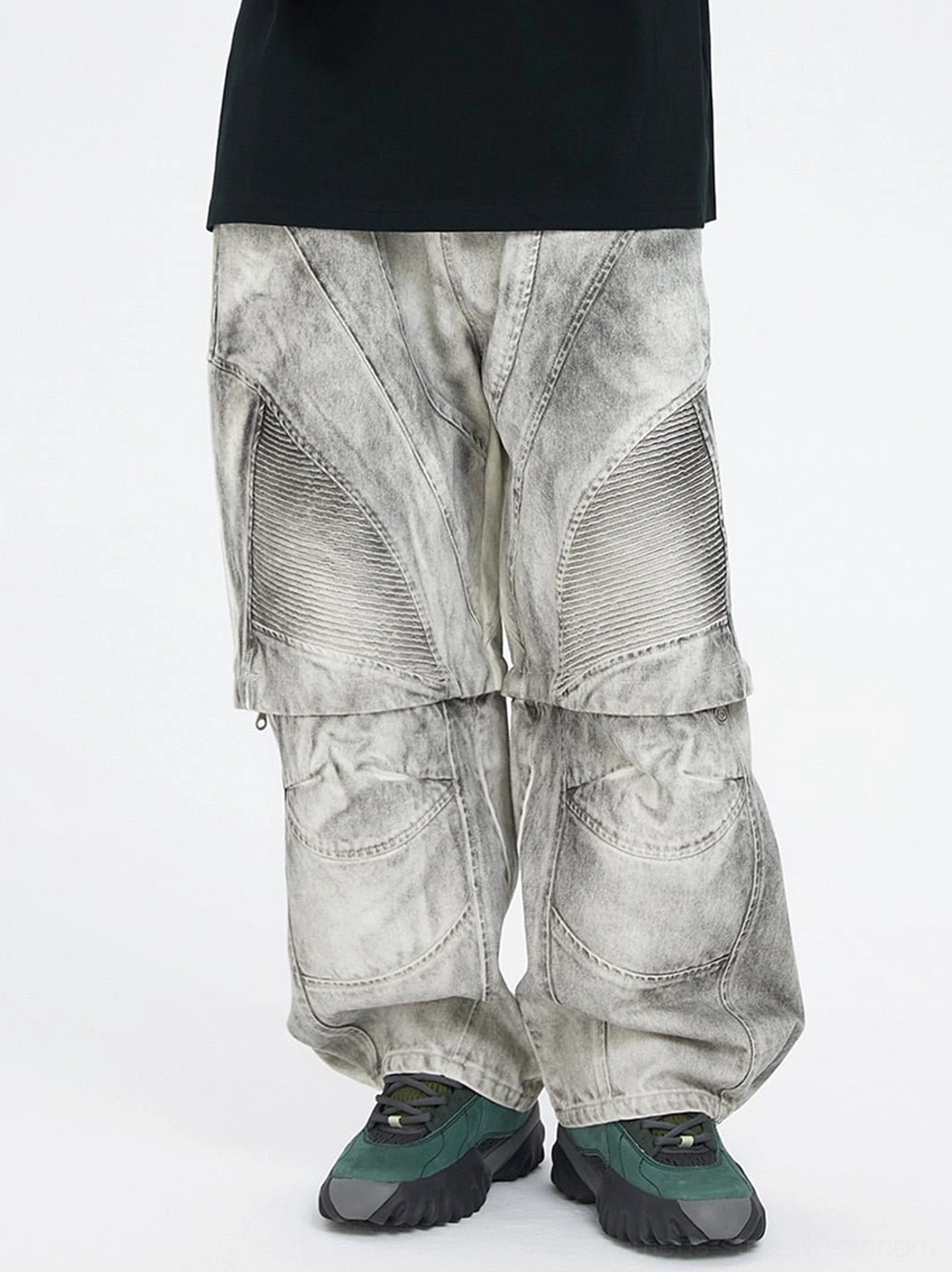 Front view of washed ash grey moto convertible cargo pants with oversized loose fit, 3D stitched panels, and dark green outdoor sneakers