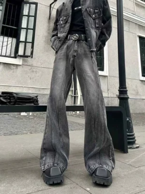 Front low angle view of washed black gray wide leg flared jeans with vertical seam details styled in an urban streetwear outfit