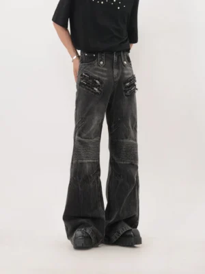 Rear view of washed black flared biker denim jeans with faded finish wide legs and classic back pockets