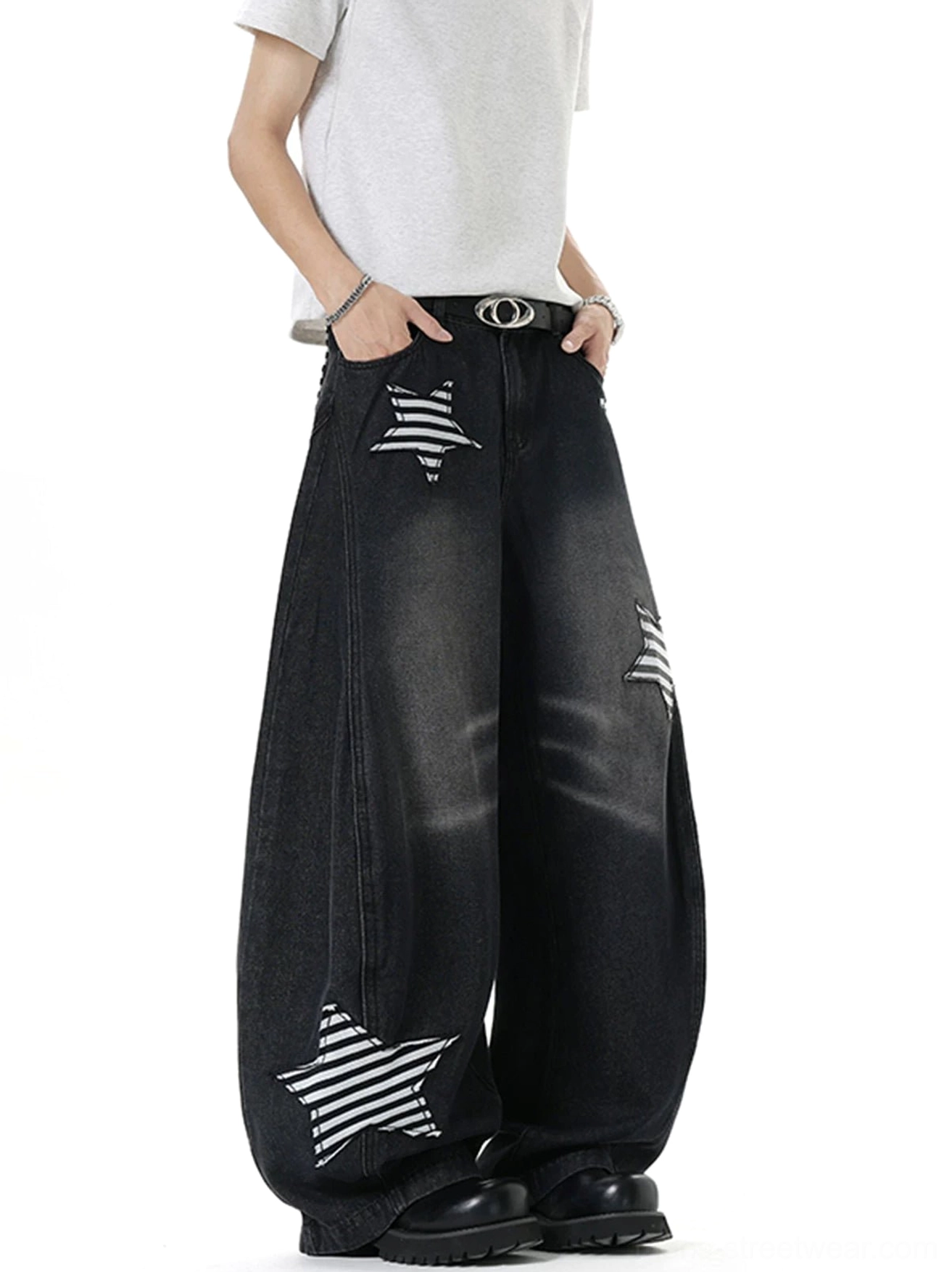 Three-quarter view of washed charcoal black balloon jeans with oversized wide legs and black white striped star patches