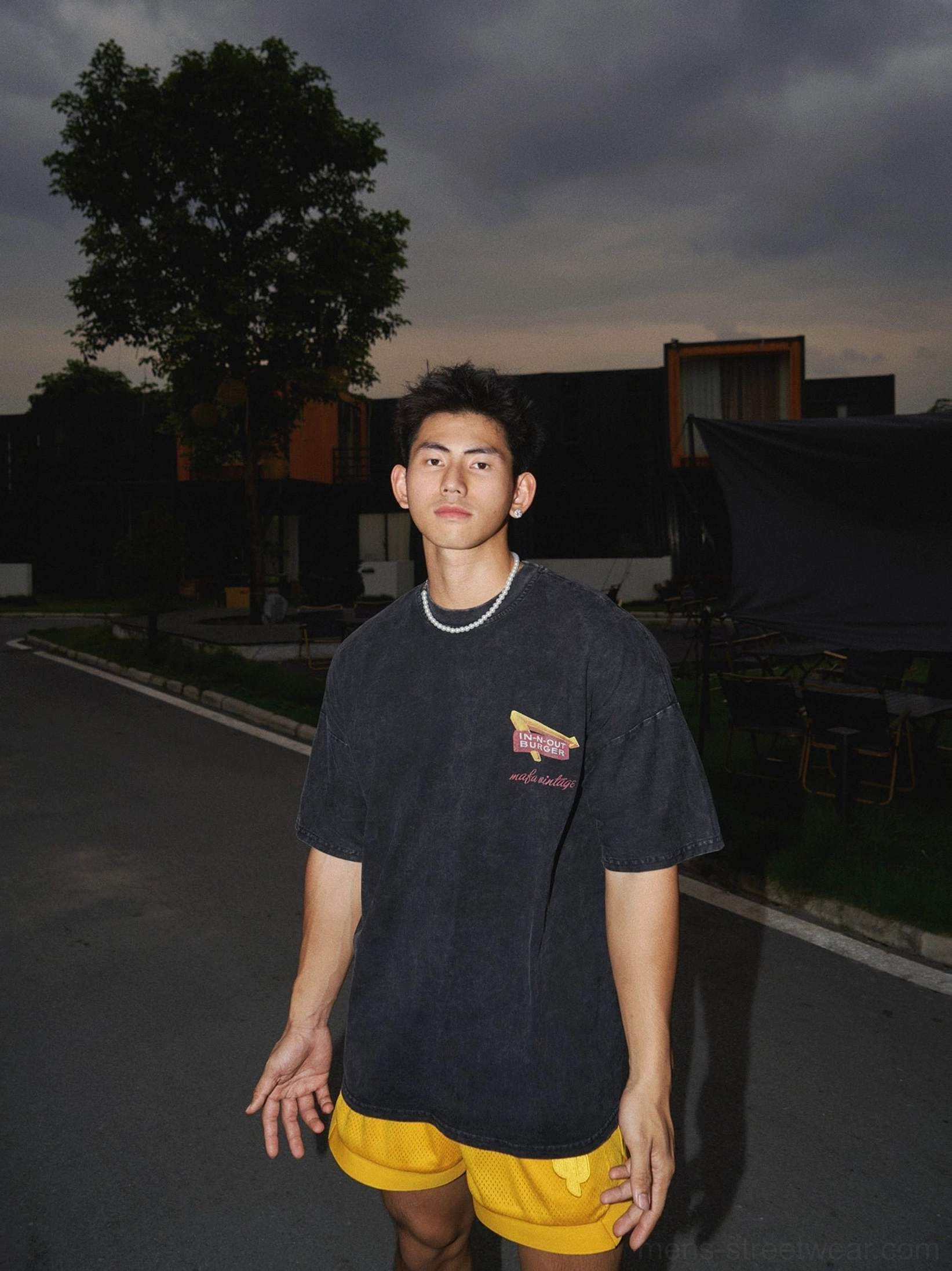 Front view of washed black relaxed fit graphic t-shirt with small diner chest print styled on male model outdoors