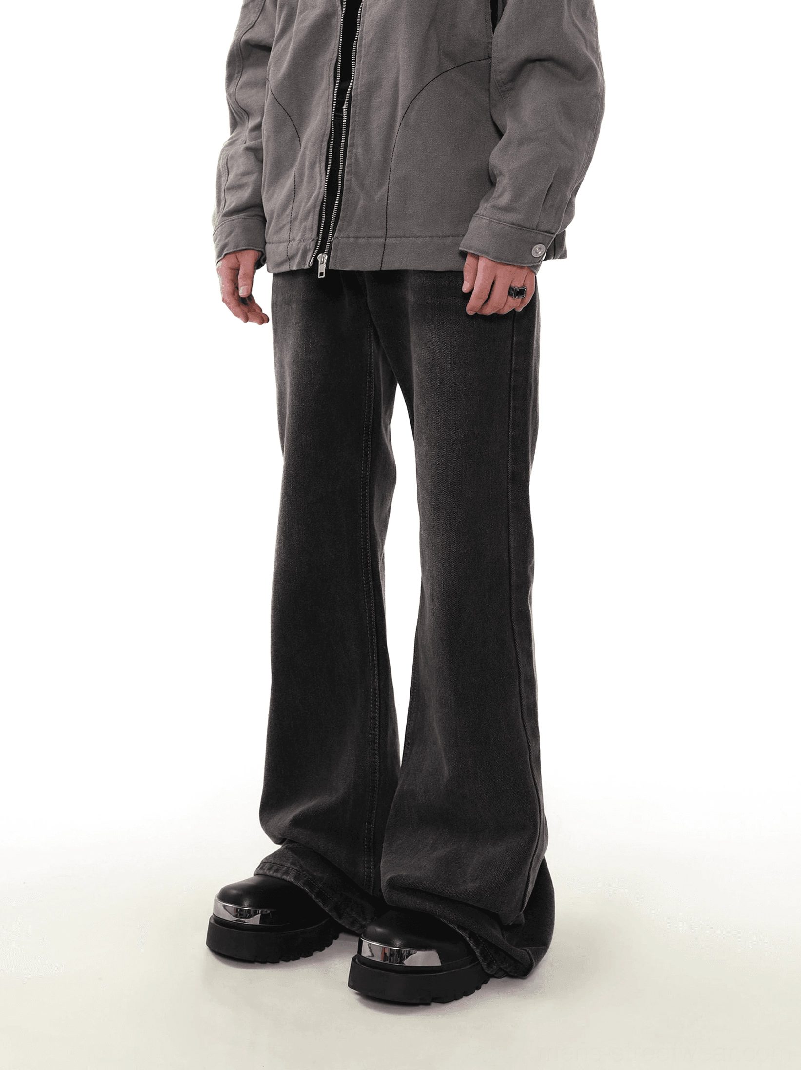 Side three-quarter view of washed black flare jeans showing relaxed fit, faded dark denim texture, and boot-covering flared hem
