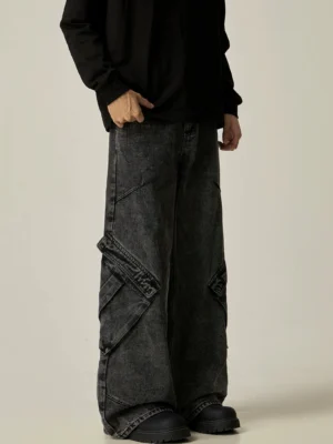 Left three-quarter view of washed black wide-leg cargo jeans with large flap utility pockets styled with a black long-sleeve top and work boots
