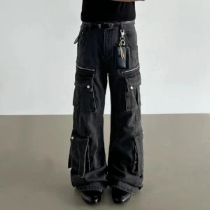 Washed black wide-leg cargo jeans worn in a low-angle front view with dimensional flap pockets and stacked streetwear silhouette