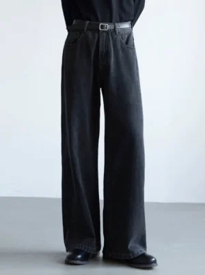Washed black wide-leg jeans shown from the front on a male model wearing a black top and leather shoes, modern Korean streetwear denim outfit