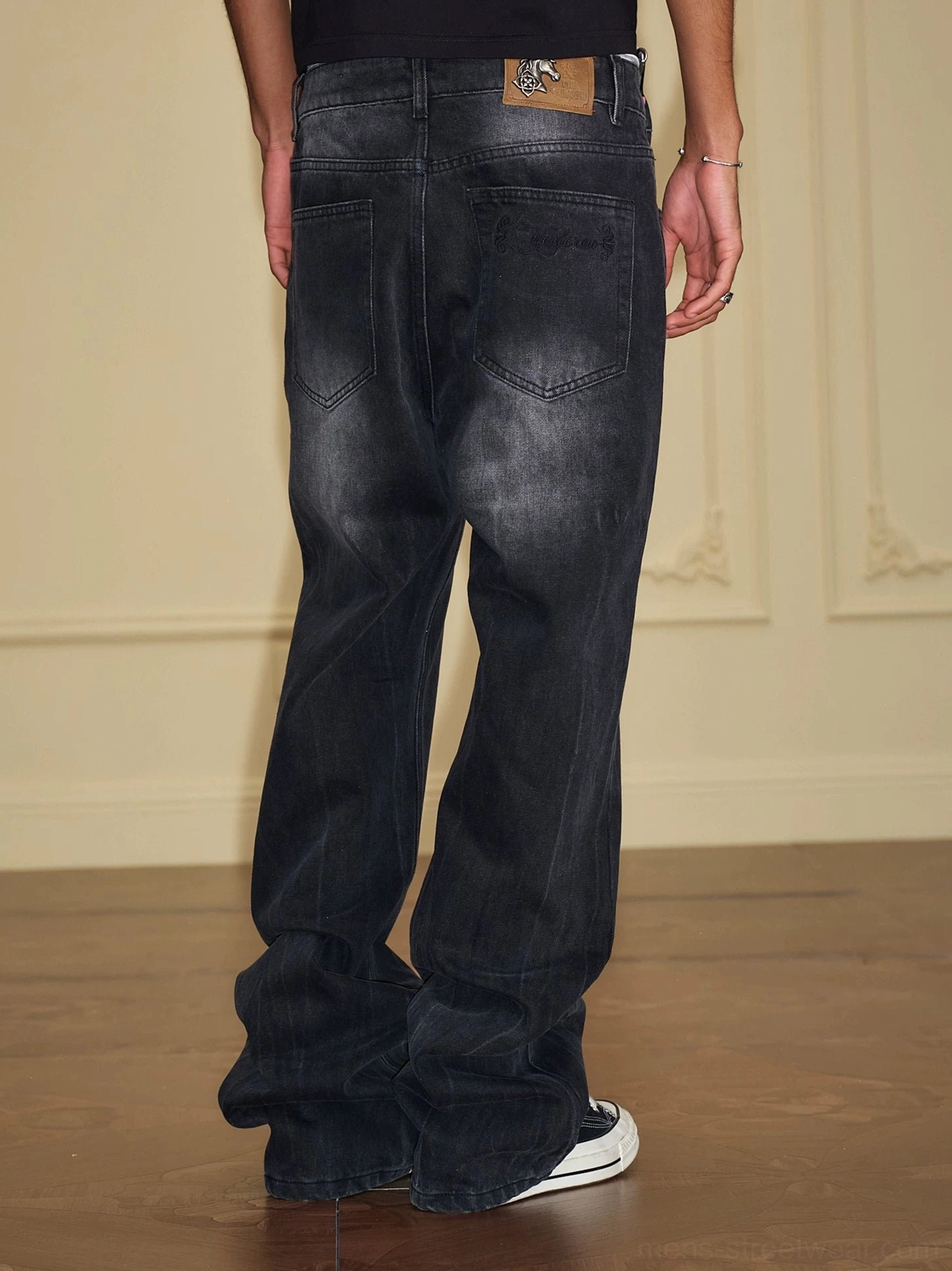 Washed black wide-leg stacked denim jeans rear view showing relaxed baggy fit and back pocket details