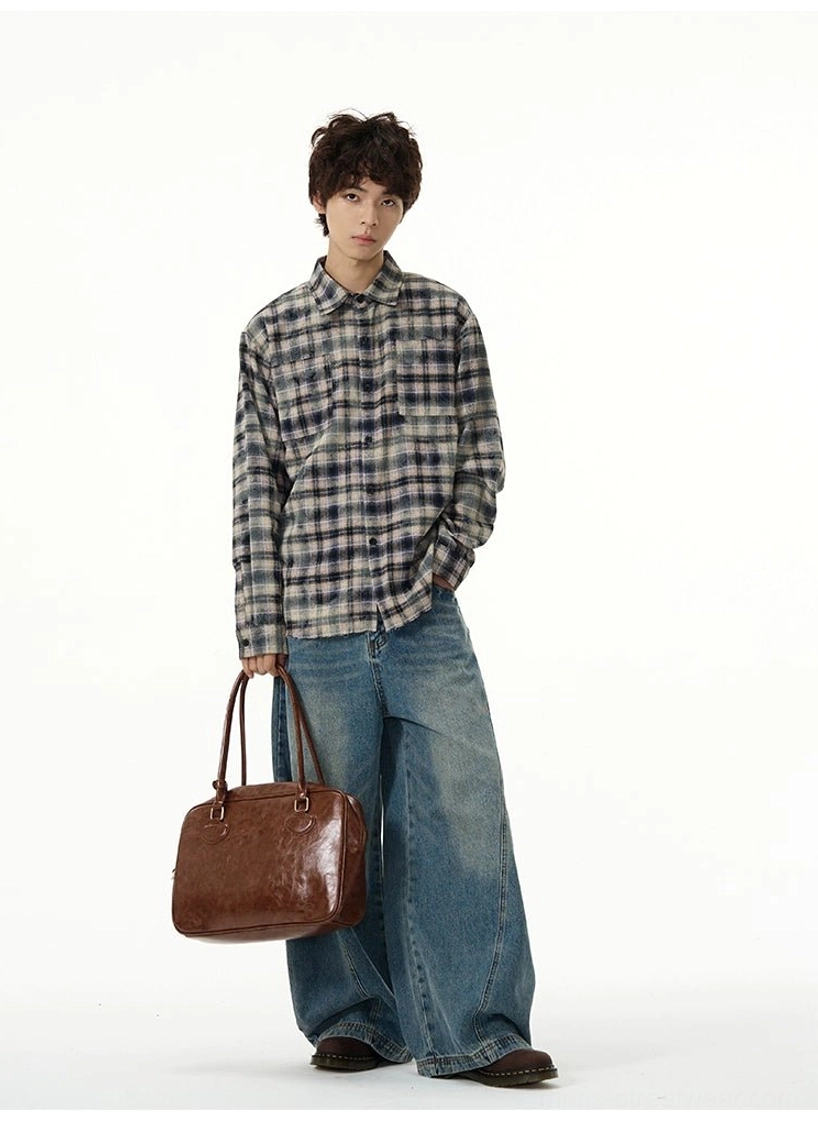Front view of relaxed washed blue balloon jeans paired with a plaid shirt and leather shoulder bag