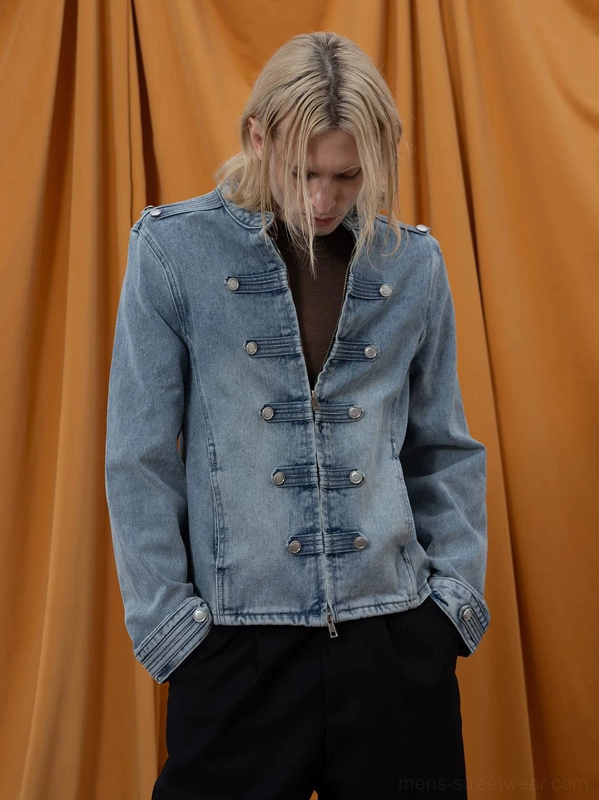 Three-quarter view of washed blue denim epaulette jacket showing concealed zip closure and tailored cropped fit