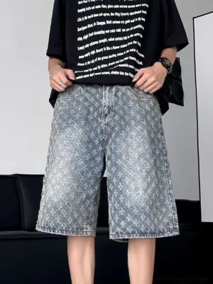 Front view of washed blue floral textured denim shorts styled with a black graphic T-shirt in a modern streetwear outfit