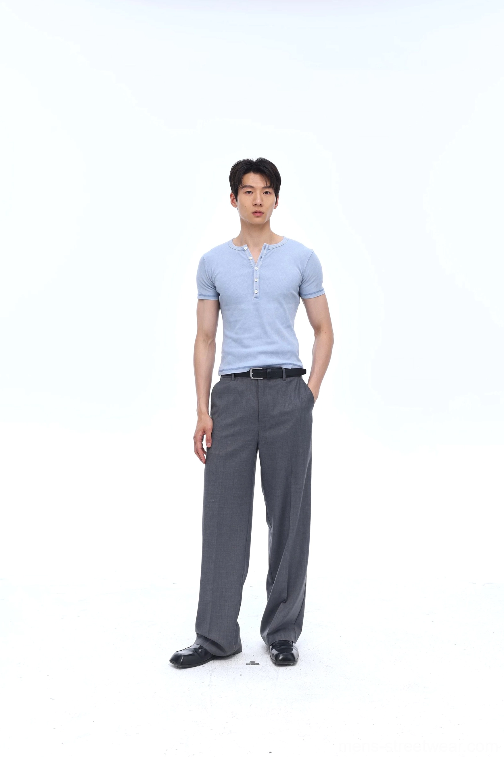 Washed blue men's Henley tee styled with grey tailored trousers, black leather belt, and dress shoes for smart casual streetwear