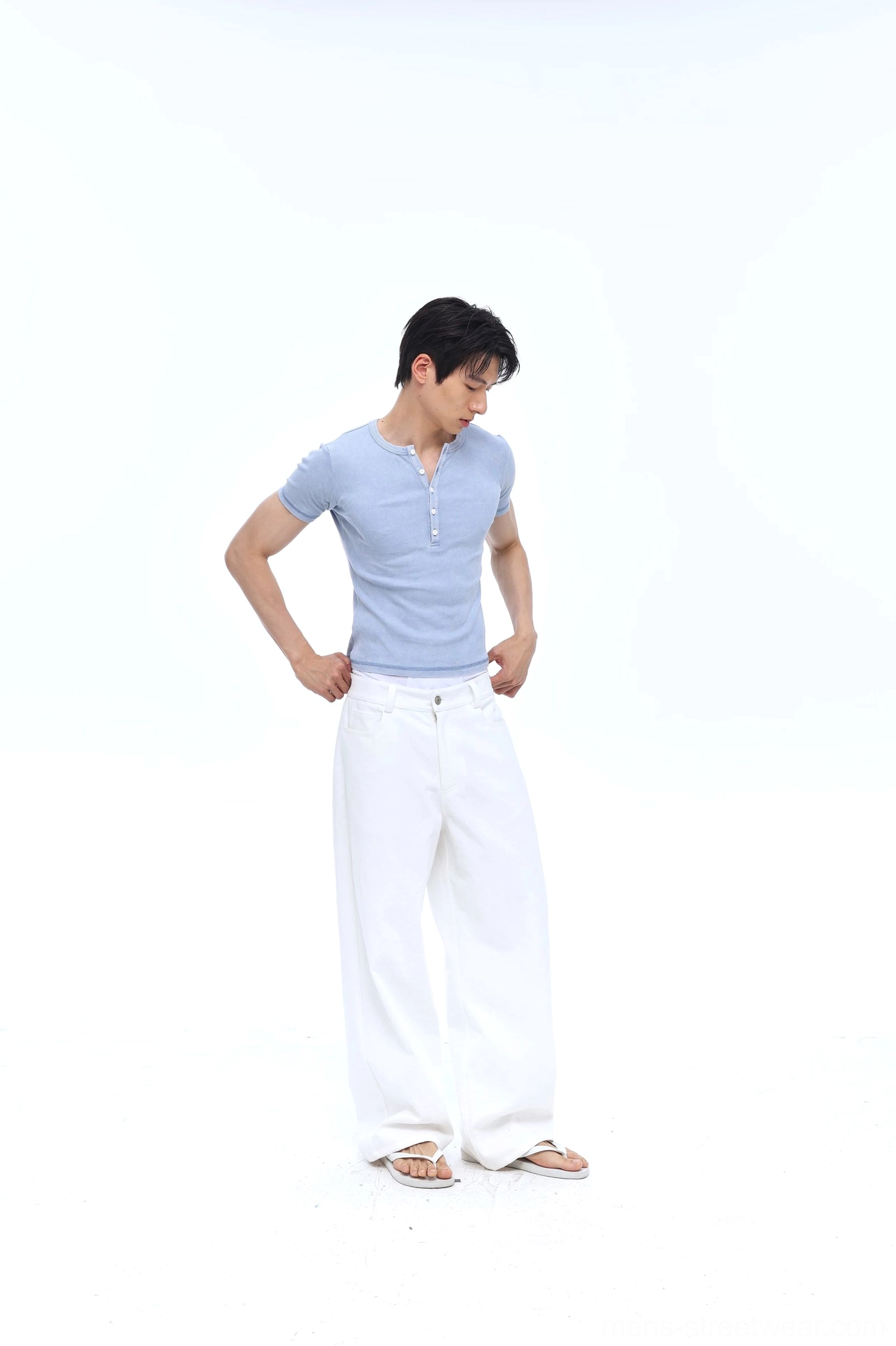 Men's washed blue Henley tee styled with white wide leg trousers in a Korean streetwear outfit with fitted ribbed short sleeves