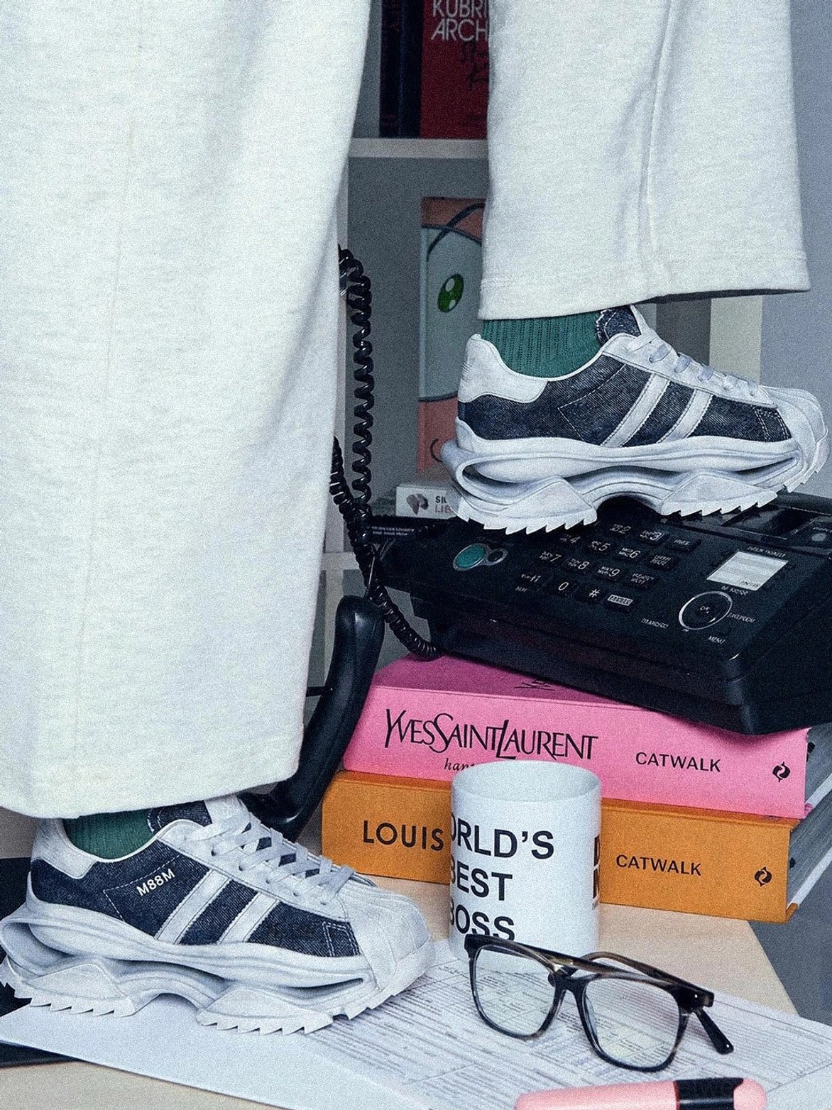 Pair of washed blue leather platform sneakers styled with light grey sweatpants and vintage-inspired accessories in a streetwear flat lay