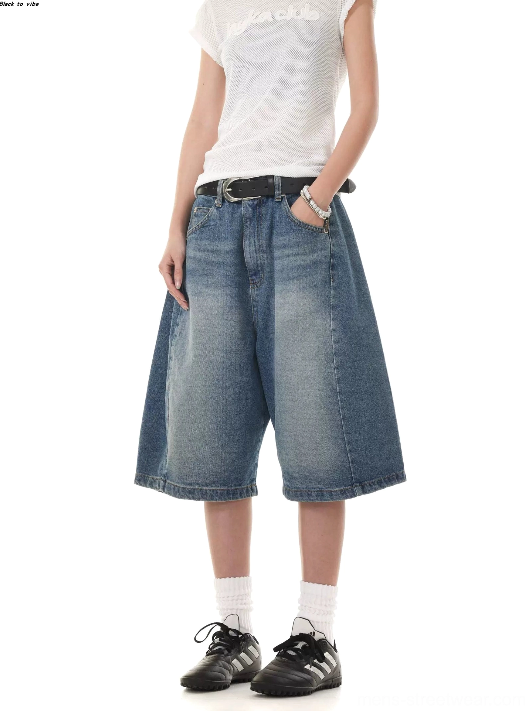 Washed blue low-rise denim Bermuda shorts with oversized wide legs shown from the front with a leather belt