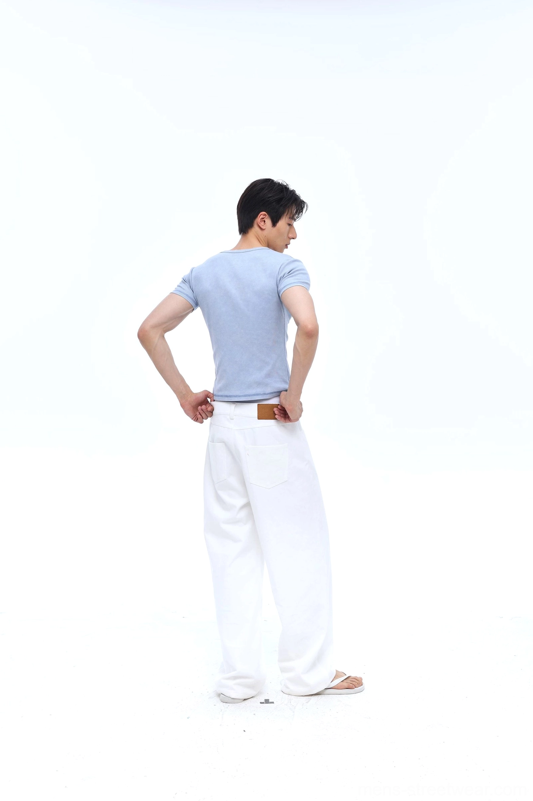 Rear view of a washed blue men's Henley ribbed tee showing the clean undecorated back and slim fitted silhouette