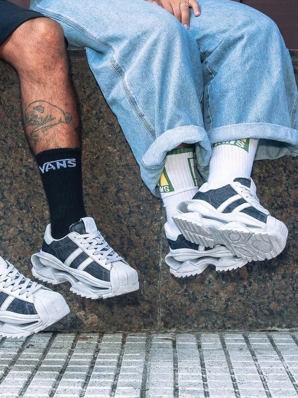Washed blue platform court sneakers worn with denim jeans in an overhead street-style outfit view showing the elevated chunky outsole