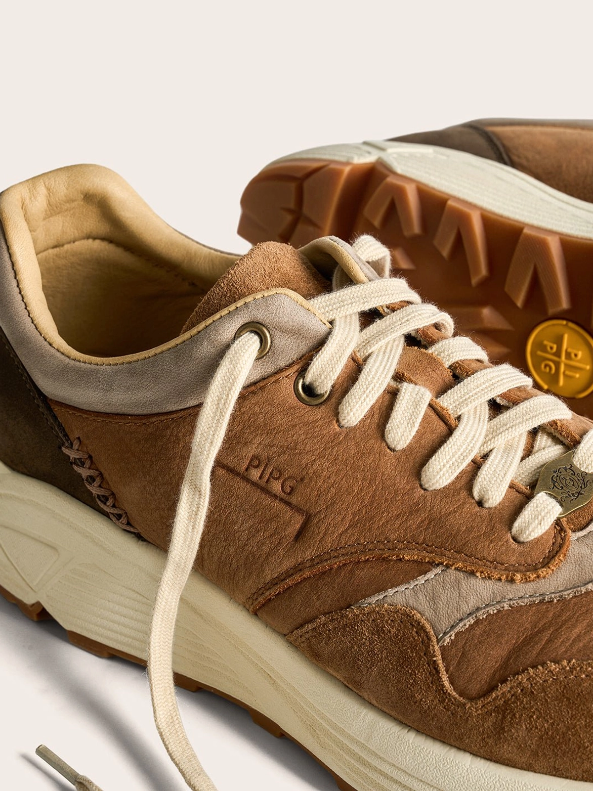 Chunky brown retro trail runner sneakers with layered panels and a grounded outdoor-inspired silhouette