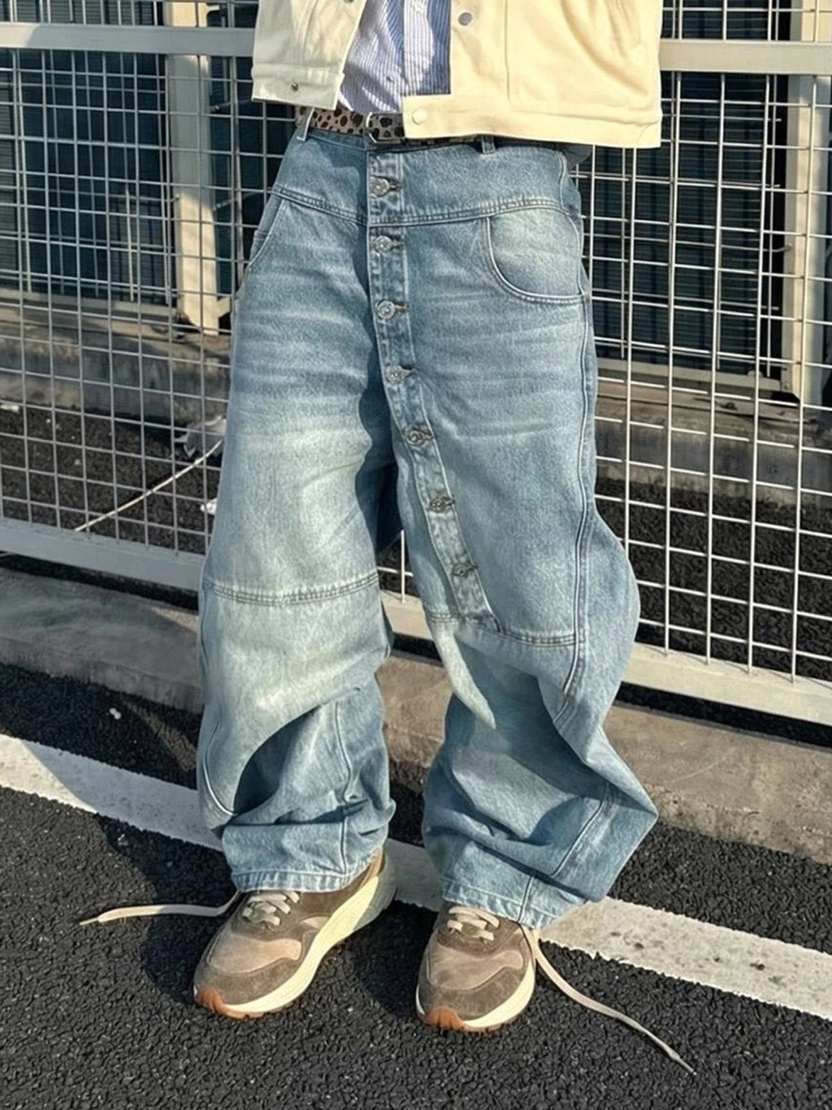 Brown retro trail runner sneakers styled with baggy light wash denim for a relaxed Korean streetwear outfit