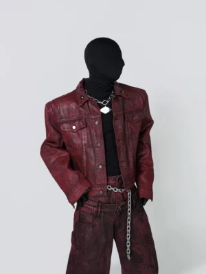 Front view of dark red cropped moto trucker jacket with snap buttons chest flap pockets and distressed leather-look finish