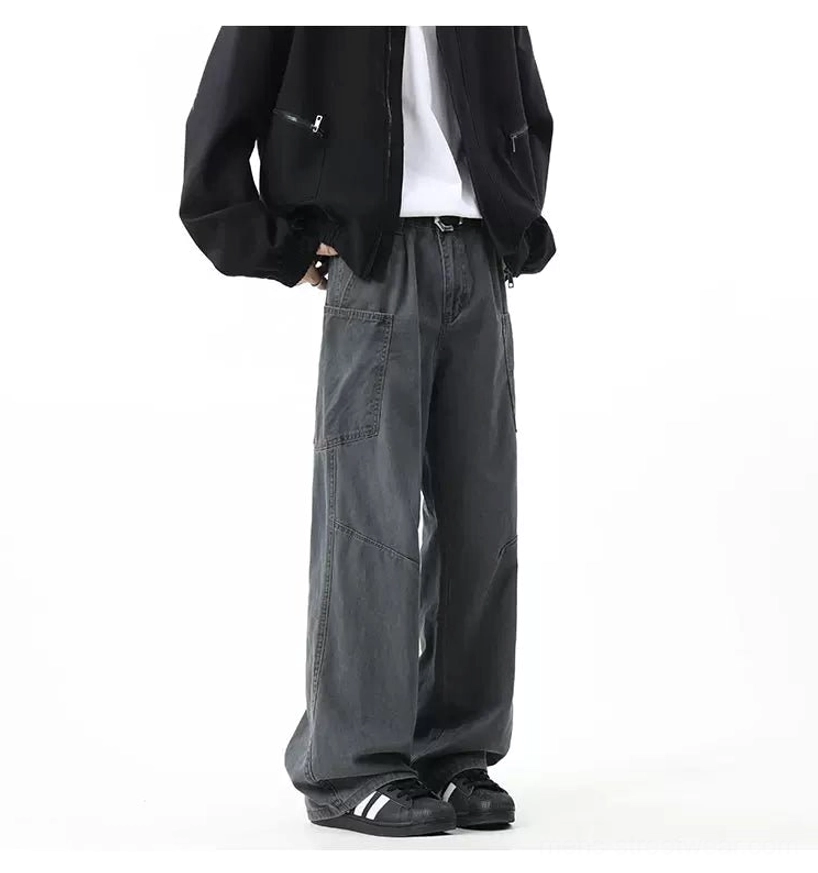 Washed charcoal grey wide-leg cargo pants shown from the rear side with large utility pockets, black jacket, white tee, and sneakers