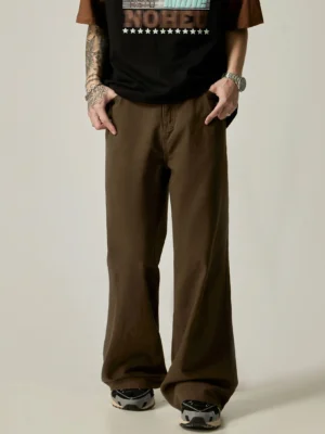 Brown washed cotton ultra-wide leg trousers with pooling hem styled with black cropped graphic t-shirt and sneakers front view