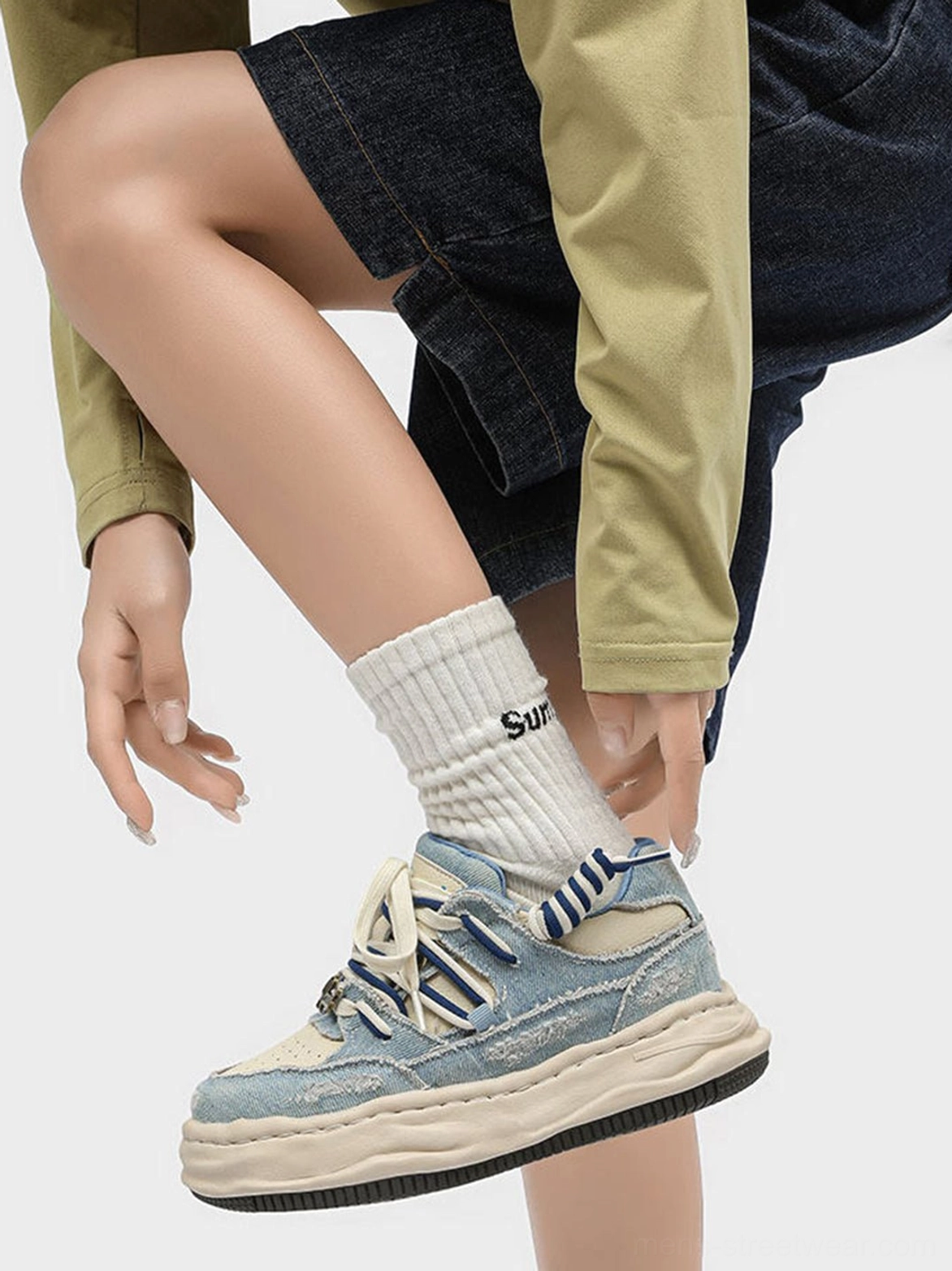 Washed denim dual-lace chunky streetwear sneaker on foot with white crew sock and dark denim shorts