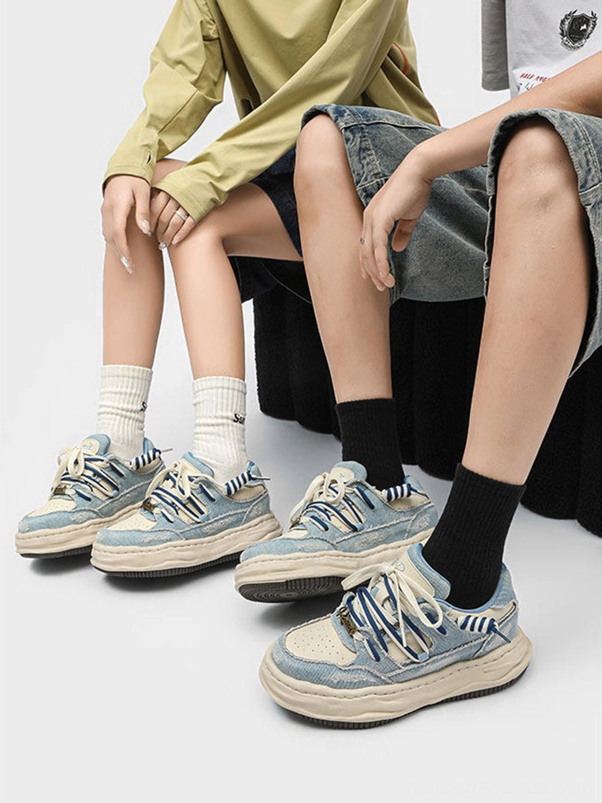 Two people wearing washed denim dual-lace chunky streetwear sneakers with casual socks and relaxed outfits