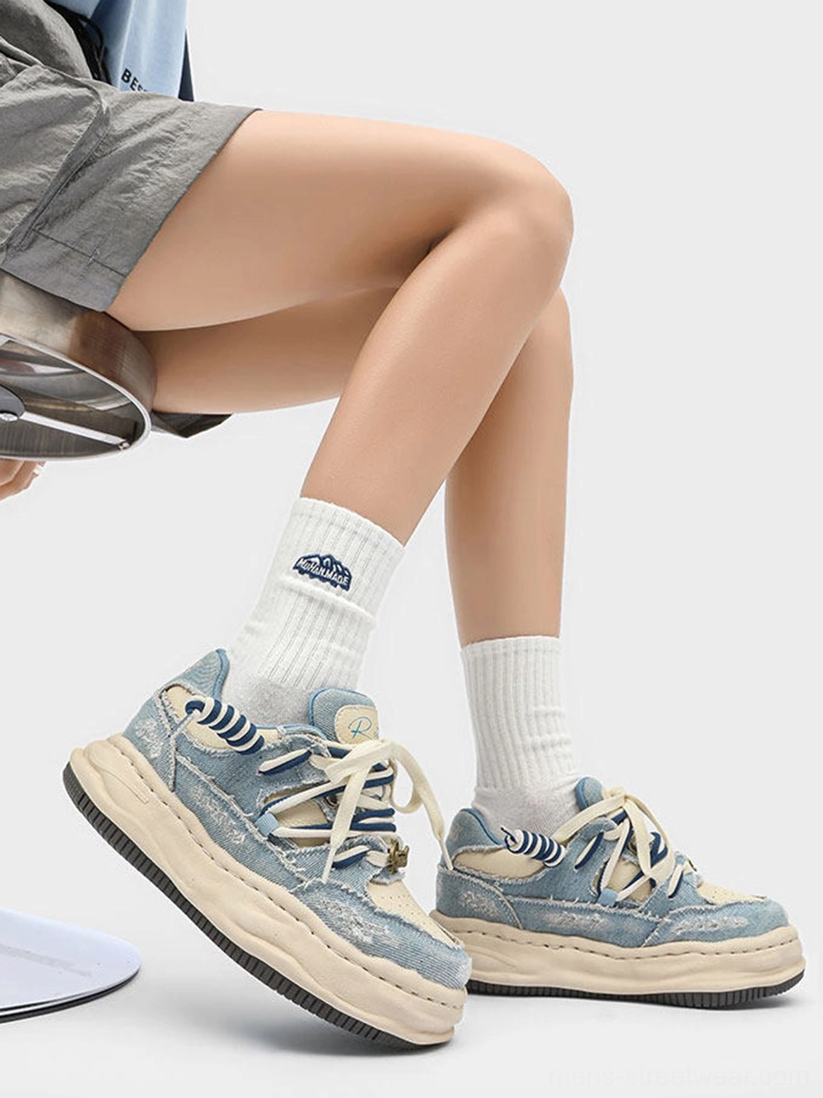 Side view of washed denim dual-lace chunky streetwear sneakers with faded blue upper and molded cream outsole