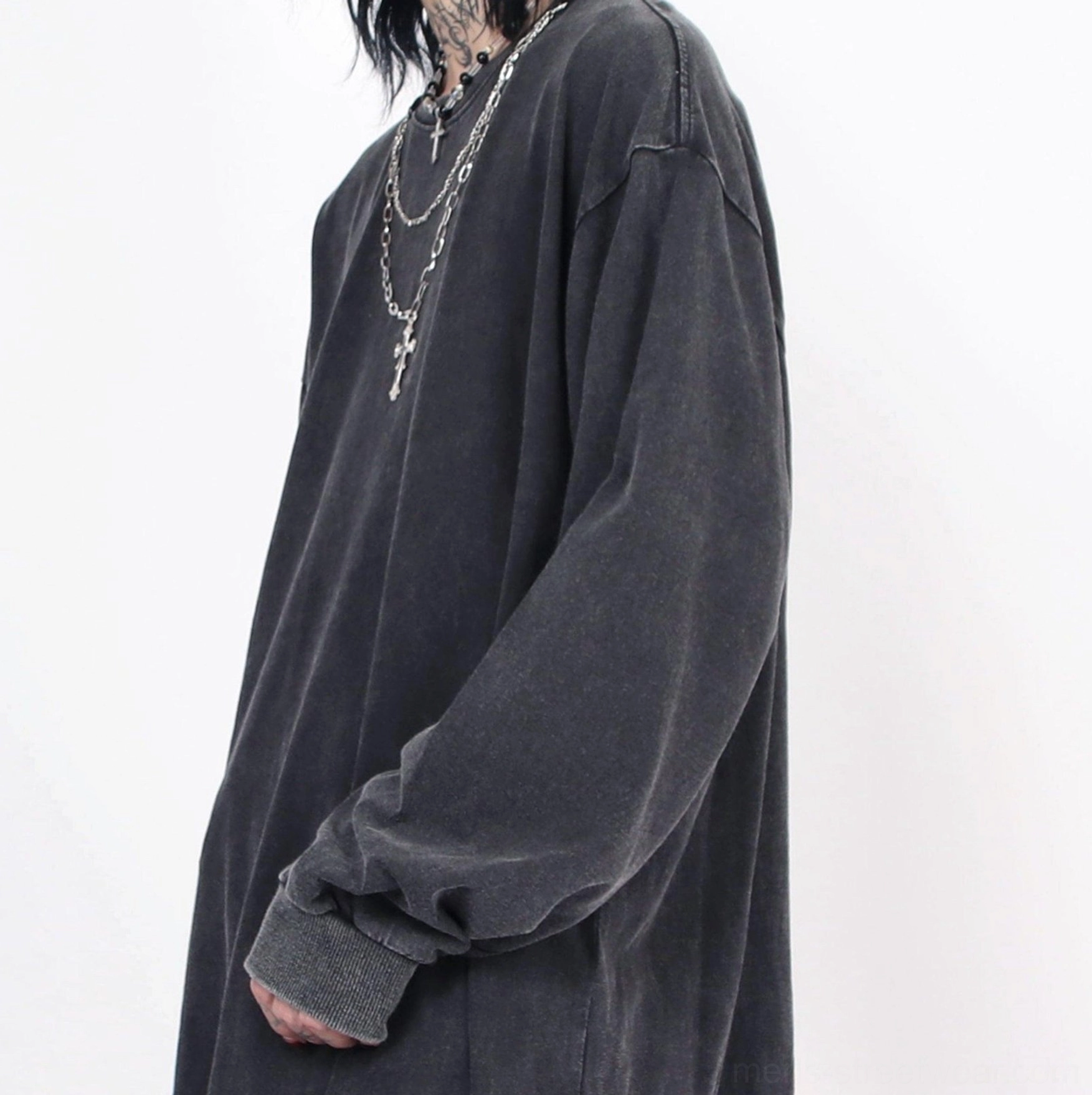 Close-up of washed distressed long-sleeve tee with dropped shoulder seams frayed cuffs and cross pendant