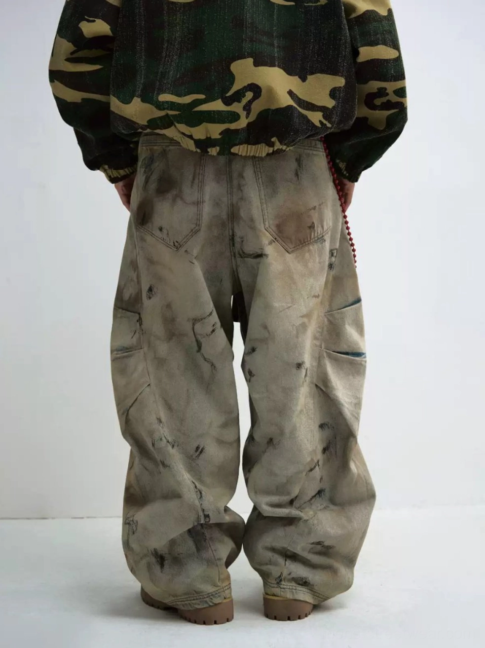 Washed distressed cargo jeans rear lower-body detail showing back pockets side cargo pocket and faded denim texture