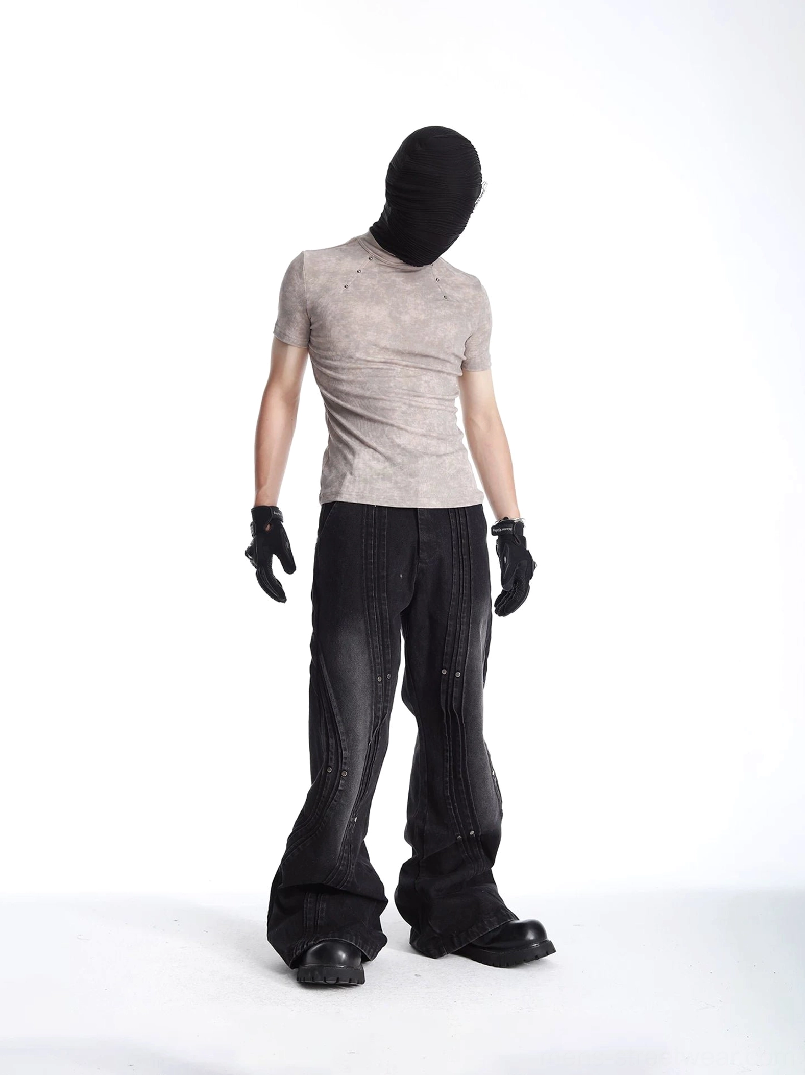 Front three-quarter view of a washed fitted crew neck T-shirt styled with black wide-leg pants boots and layered streetwear accessories