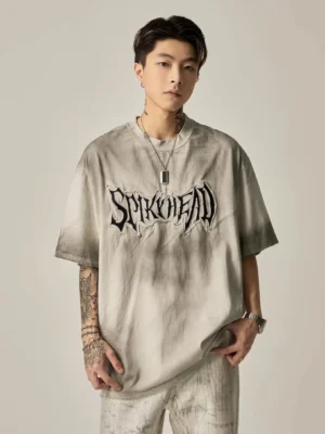 Angled view of washed gray oversized cotton grunge T-shirt with gothic chest embroidery